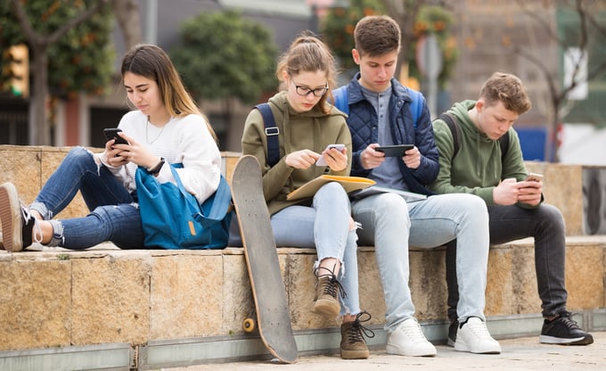 Jugendliche gucken auf ihr Smartphone